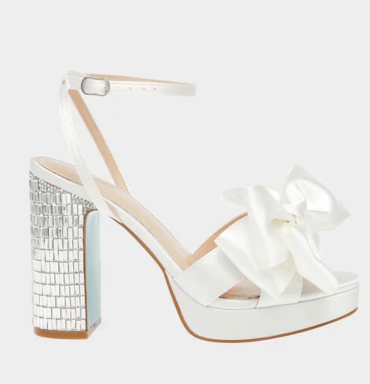 a woman's white high heeled sandal with a bow