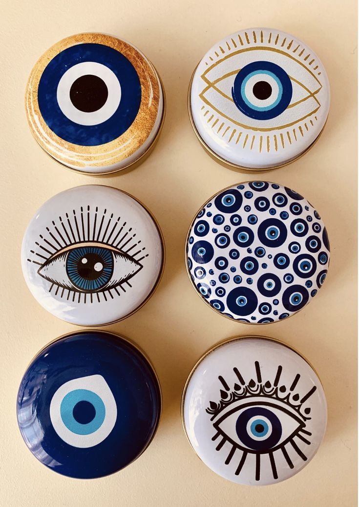 four plates with different designs on them and one has an evil eye painted on it