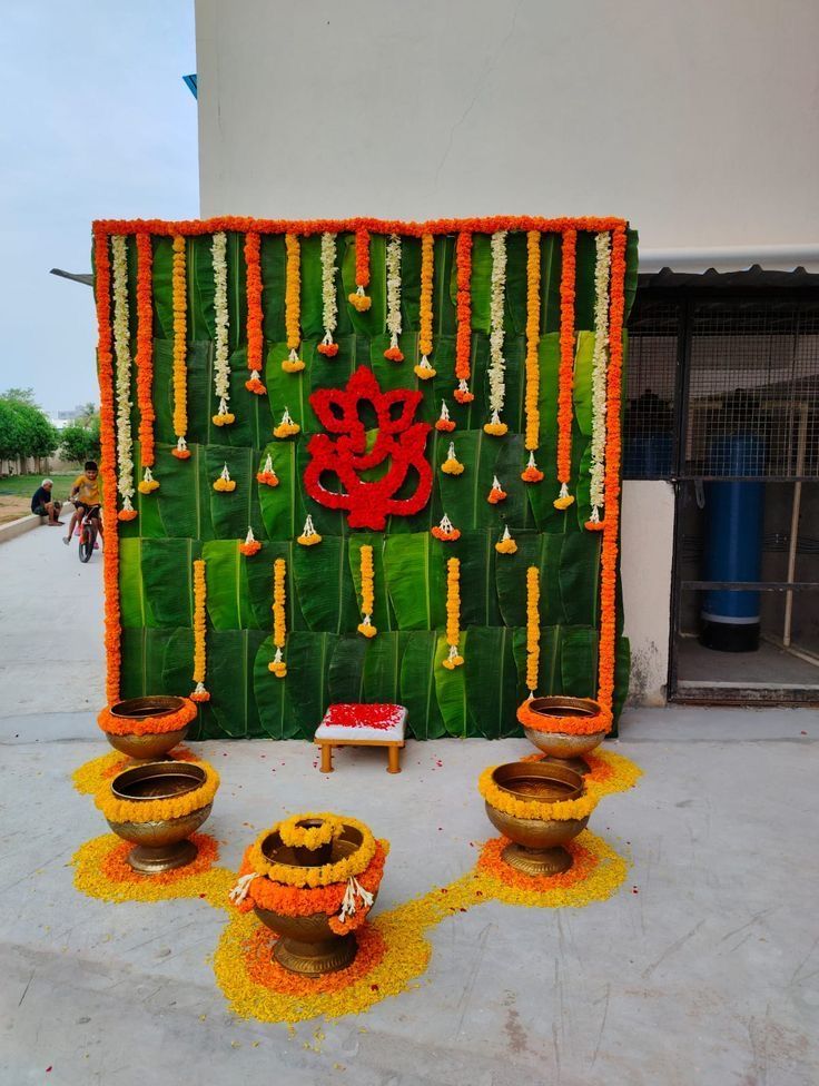 a decorated wall with flowers and candles on the ground