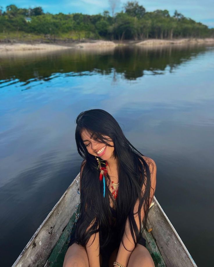 a woman is sitting in a boat on the water