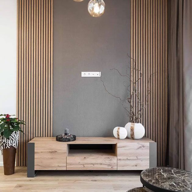 a modern living room with wood paneling and white vases on the coffee table