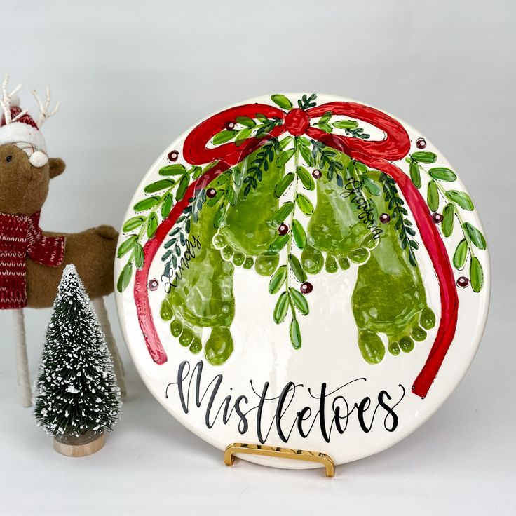 a ceramic plate decorated with christmas decorations and a reindeer figurine next to it