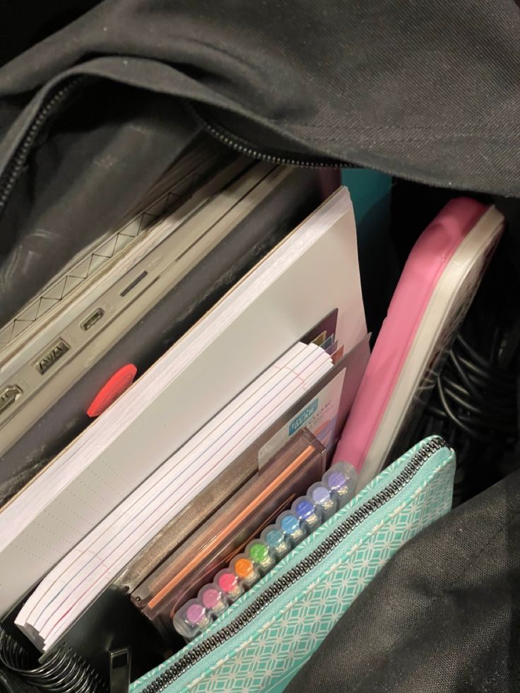 an open backpack filled with school supplies such as pens, pencils, and markers