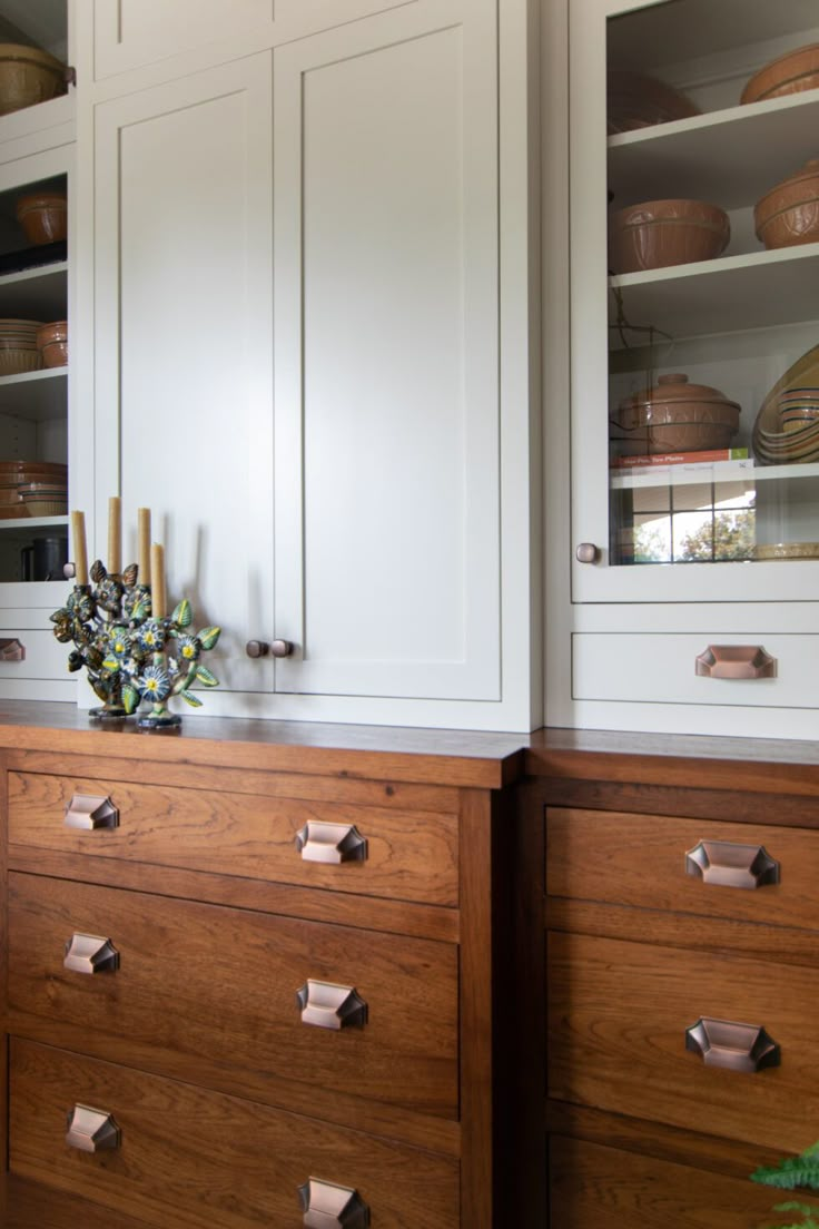 the cabinets in this kitchen are white and have brass pulls on them to match the wood