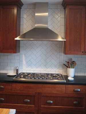 a stove top oven sitting inside of a kitchen next to wooden cabinets and counter tops