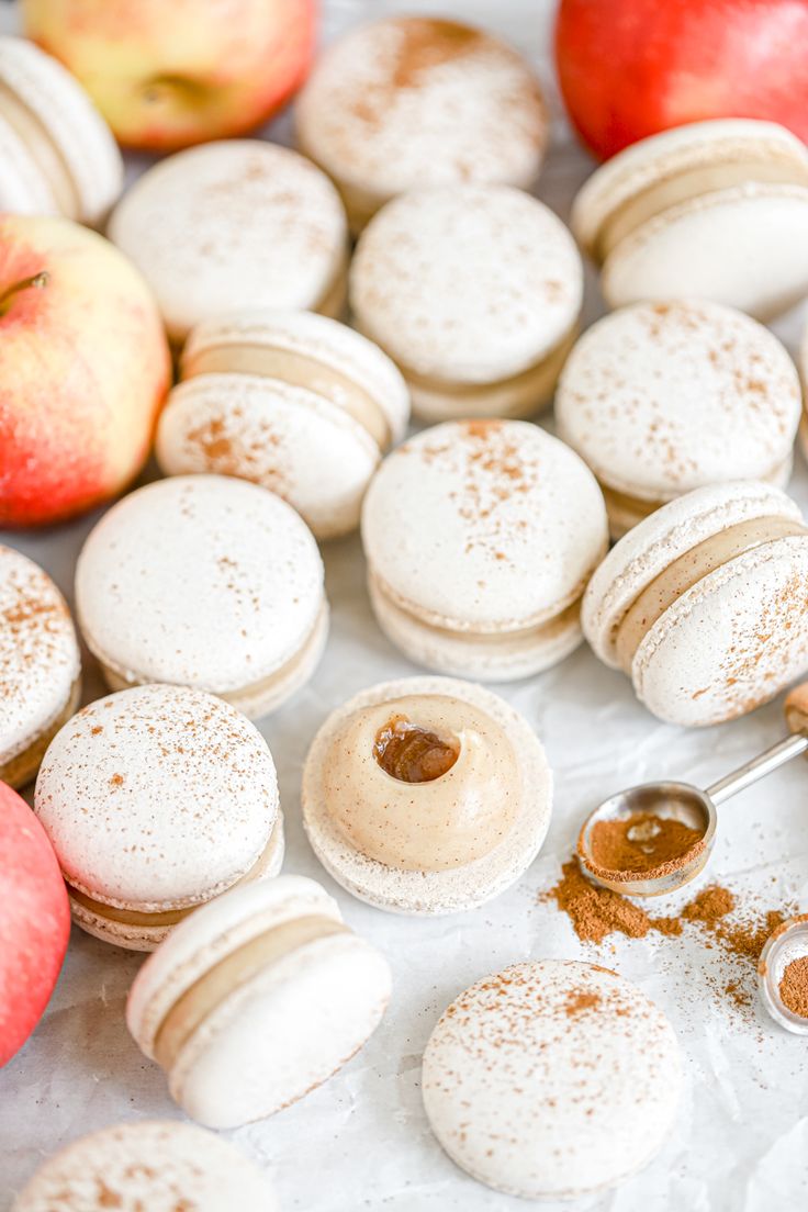 macaroons and apples on a table with powdered sugar in the top half