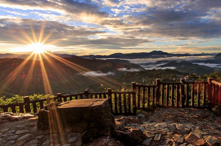 the sun shines brightly over mountains and valleys in this scenic view from an overlook point