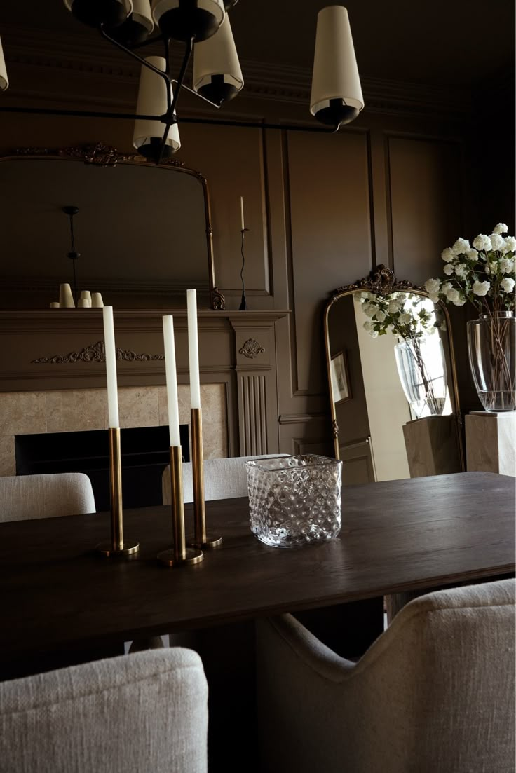 a dining room table with candles and flowers on it