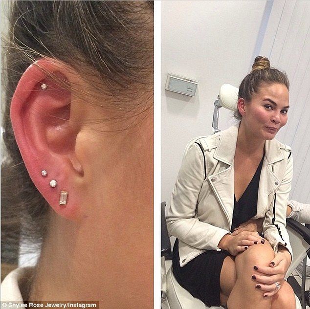 a woman sitting in a chair next to an ear piercing