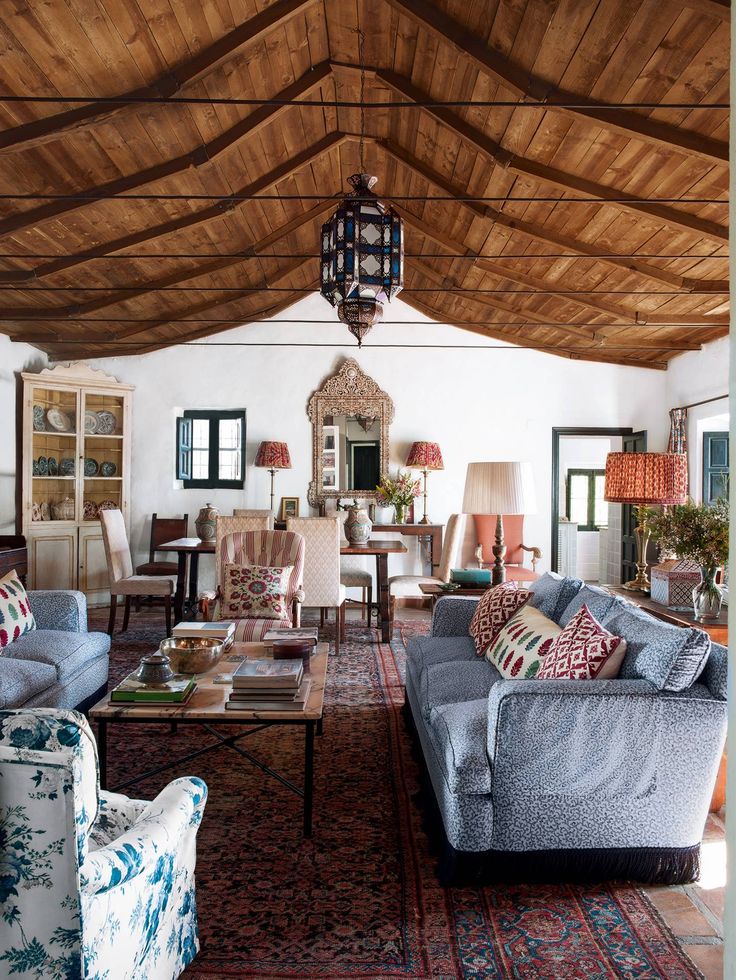 a living room with couches, chairs and tables inside of it on top of a rug