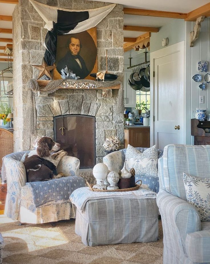 a living room filled with furniture and a fire place in front of a stone fireplace