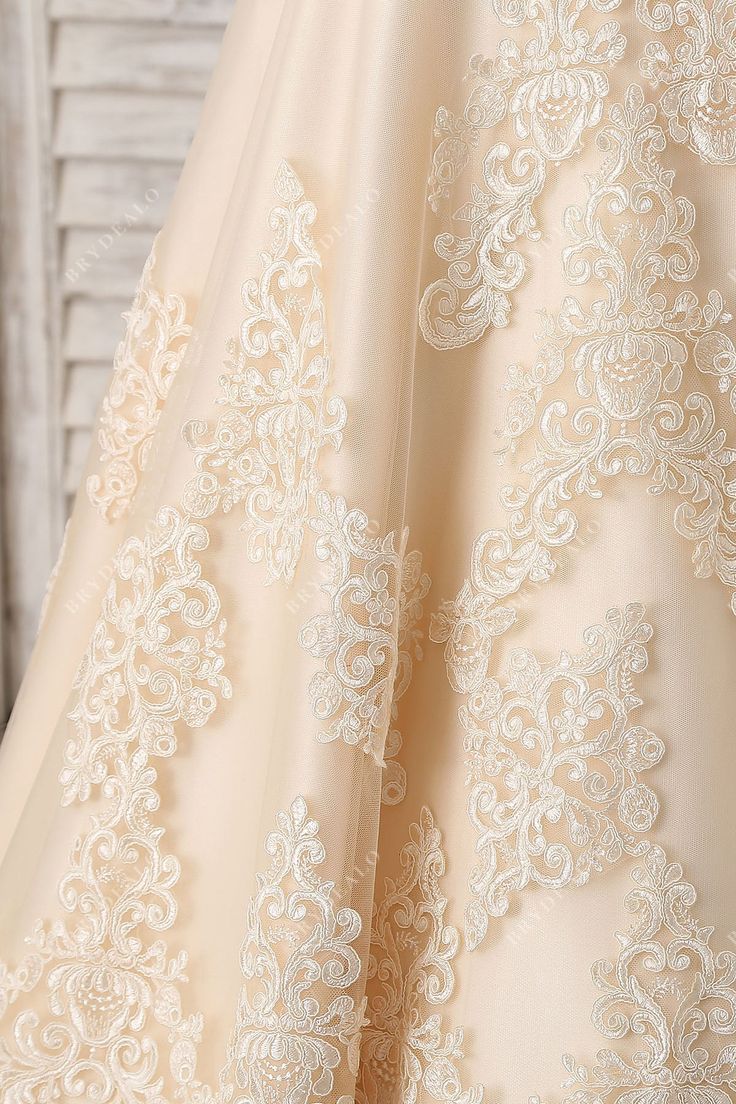 the back of a wedding dress with white lace on it