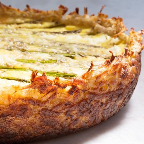 a quiche with cheese and asparagus on top