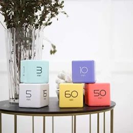 four cubes with numbers on them sitting on a table next to a vase filled with flowers