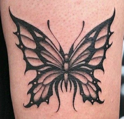 a black and white butterfly tattoo on the leg