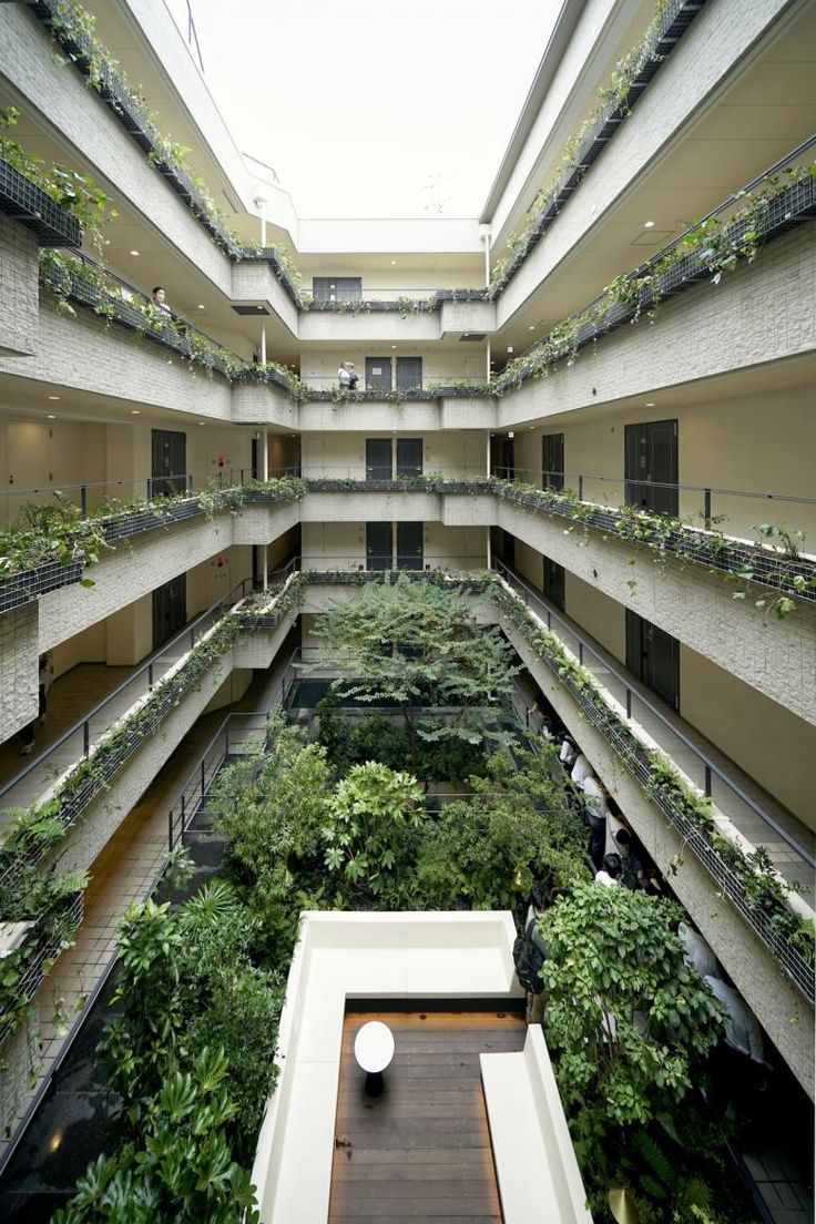 an atrium filled with lots of plants and greenery on both sides of the building