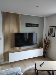 a flat screen tv sitting on top of a white entertainment center in a living room