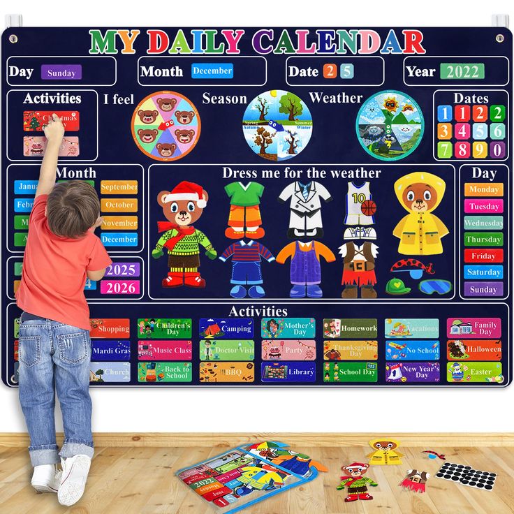 a young boy is playing with his calendar poster in front of the wall and toys on the floor