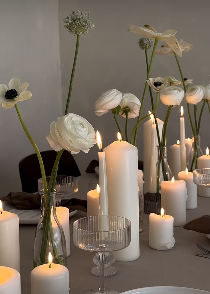 there are many white candles on the table