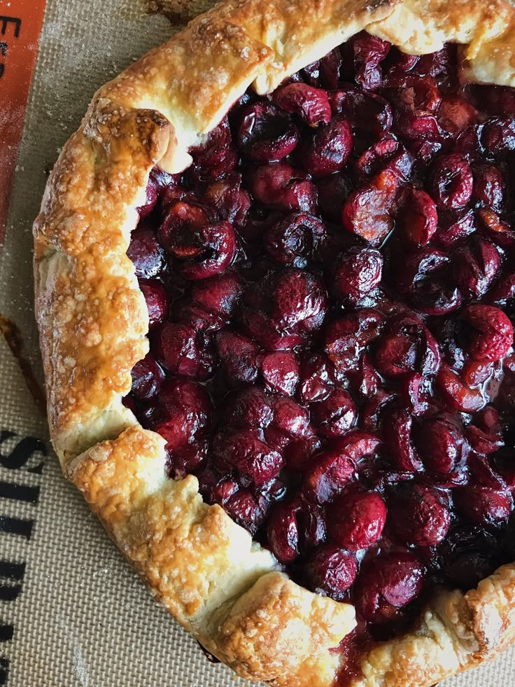 a pie with cranberries on it sitting on top of a piece of paper