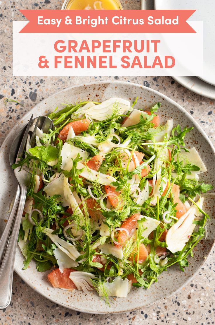 a white plate topped with salad next to a glass of orange juice and silverware