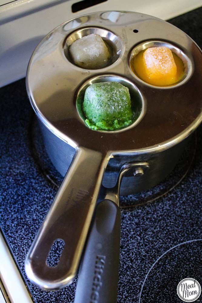 an electric stove with three trays filled with food on the burners and ice cubes in them