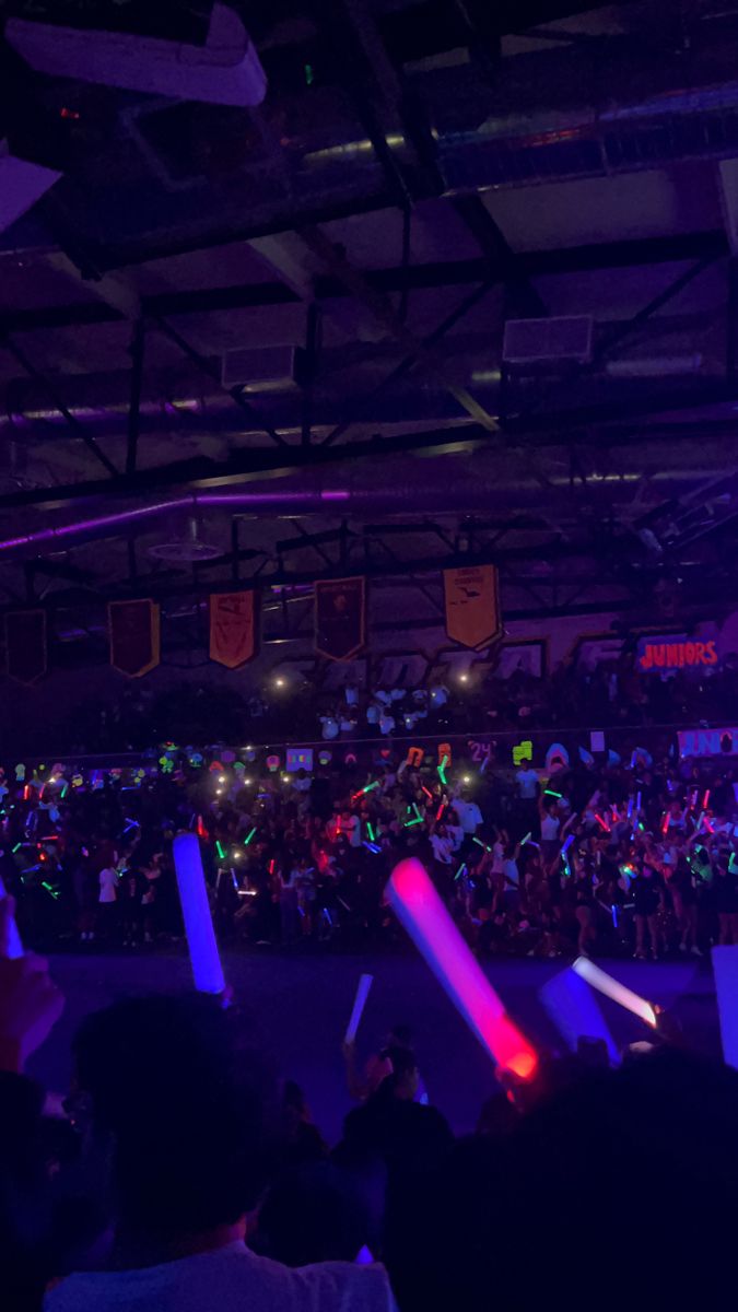 a large group of people in a room with lights and remotes on the floor