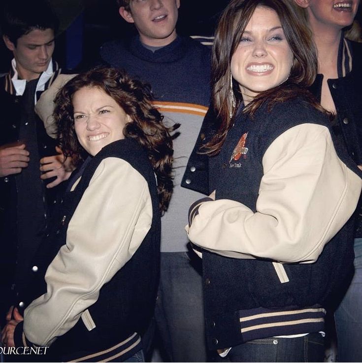 two women standing next to each other smiling