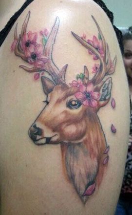 a woman's thigh with a deer tattoo on it