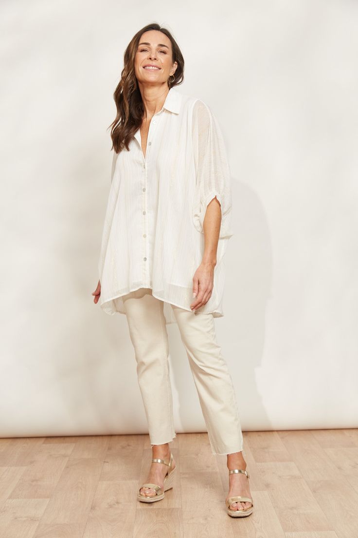 STYLE DETAILS: Workwear that does weekends, the Sereno Relaxed Shirt is the ultimate multitasker. In a relaxed fit, this shirt offers a flattering fit for all shapes and sizes. It features classic details, elevated by batwing sleeves, a flowing high-low hem, and shimmering lurex threading for that extra sparkle. Tuck it into a maxi skirt for a professional look or with fitted denim jeans for a chic weekend vibe. FEATURES: Collar Button-down Elbow-length batwing sleeves with cuff Lurex threading High-low hem Relaxed fit 100% Polyester Lining: 100% Rayon One Size Relaxed Fit Shirt For Daywear, Effortless Daywear Shirt With Rolled Sleeves, Relaxed Collared Shirt For Daywear, Versatile Collared Shirt With Relaxed Fit, Everyday Relaxed Collared Blouse, Effortless Blouse With Rolled Sleeves In Relaxed Fit, Versatile White Blouse For Day Out, White Effortless Collared Top, Relaxed Collared Blouse For Daywear