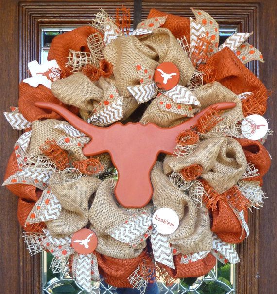 this wreath is made with burlocks and an orange cow head on the front door