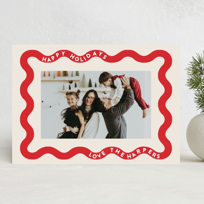 a christmas card with an image of two women and a man holding a small child