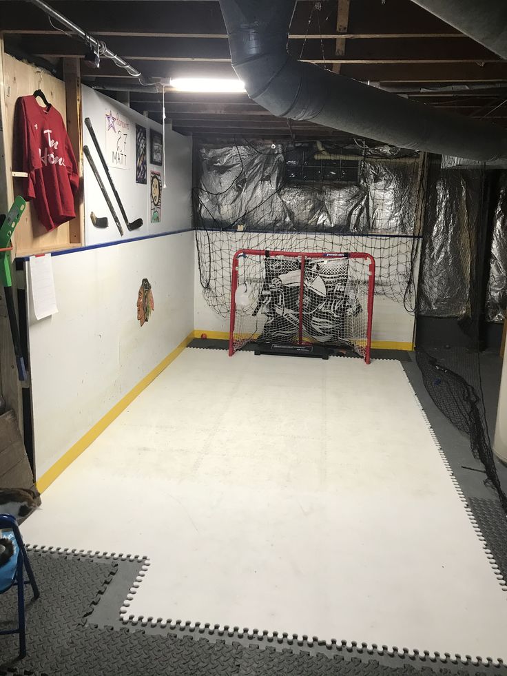 an indoor hockey rink with net, goal and equipment on the wall in front of it