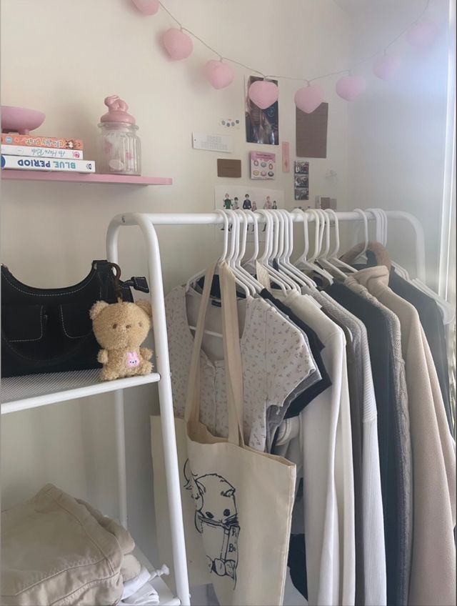 there is a rack with clothes and a teddy bear on the hanger next to it