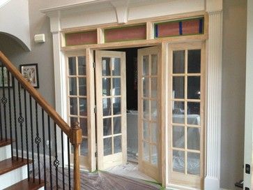 an entry way with glass doors and wooden steps