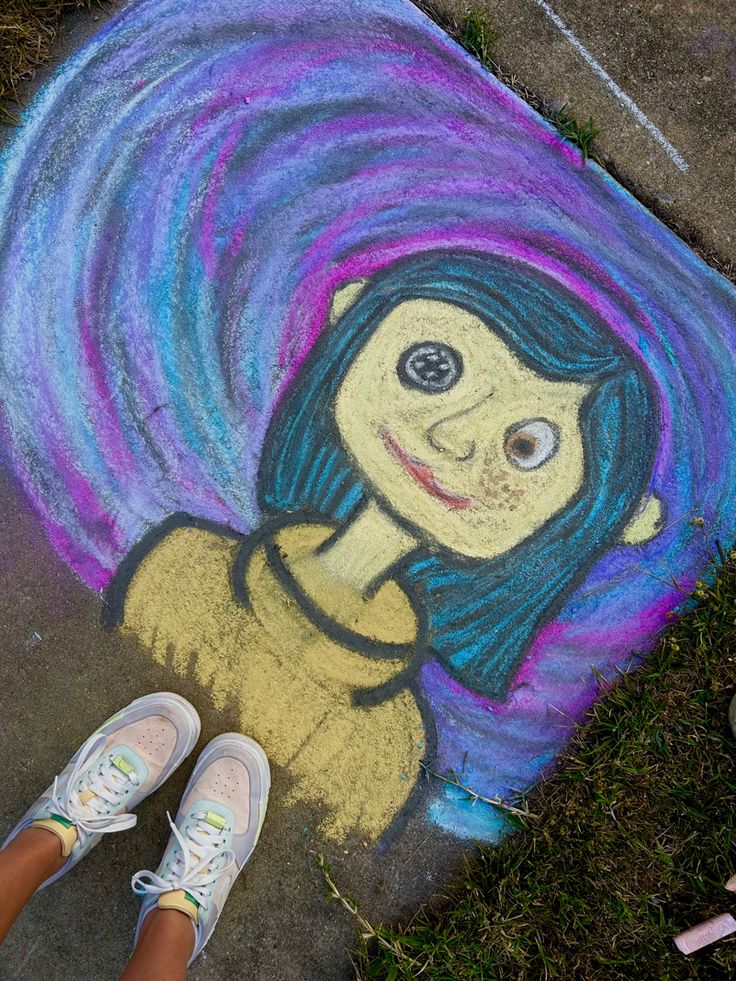 a person standing next to a chalk drawing of a girl