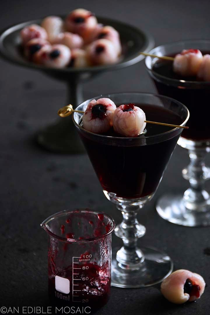 two glasses filled with desserts on top of a black table next to each other