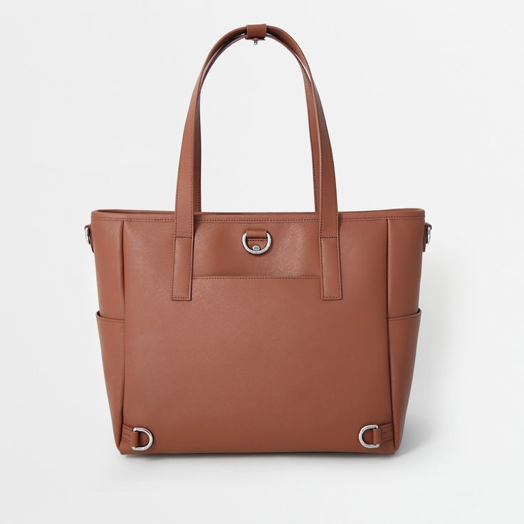 This structured tote is the ultimate do-it-all bag that you deserve. It's the perfect carryall for work, travel, and anywhere your day brings you. It features a spacious and organized interior for your essentials, a padded compartment for your laptop, side pockets for your drinks, and you can convert it into a backpack or crossbody. Crafted from premium American Saffiano leather that's waterproof and scratch-resistant, the Transform Tote will stay just as beautiful through all your travels and a Office Tote Shoulder Bag With Luggage Sleeve, Large Capacity Tote Briefcase For Work, Office Satchel With Luggage Sleeve In Tote Shape, Versatile Cognac Satchel For Travel, Office Tote Satchel With Luggage Sleeve, Versatile Brown Briefcase For Everyday Use, Office Satchel With Luggage Sleeve And Tote Shape, Luxury Everyday Tote Laptop Bag, Modern Laptop Bag With Double Leather Handles