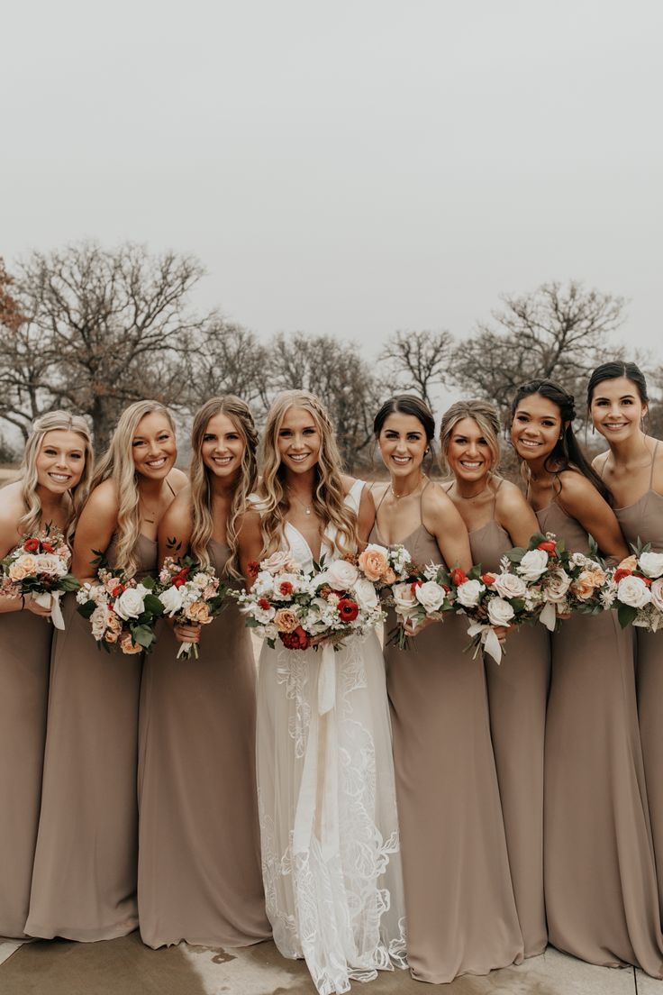 a group of women standing next to each other holding bouquets in front of them