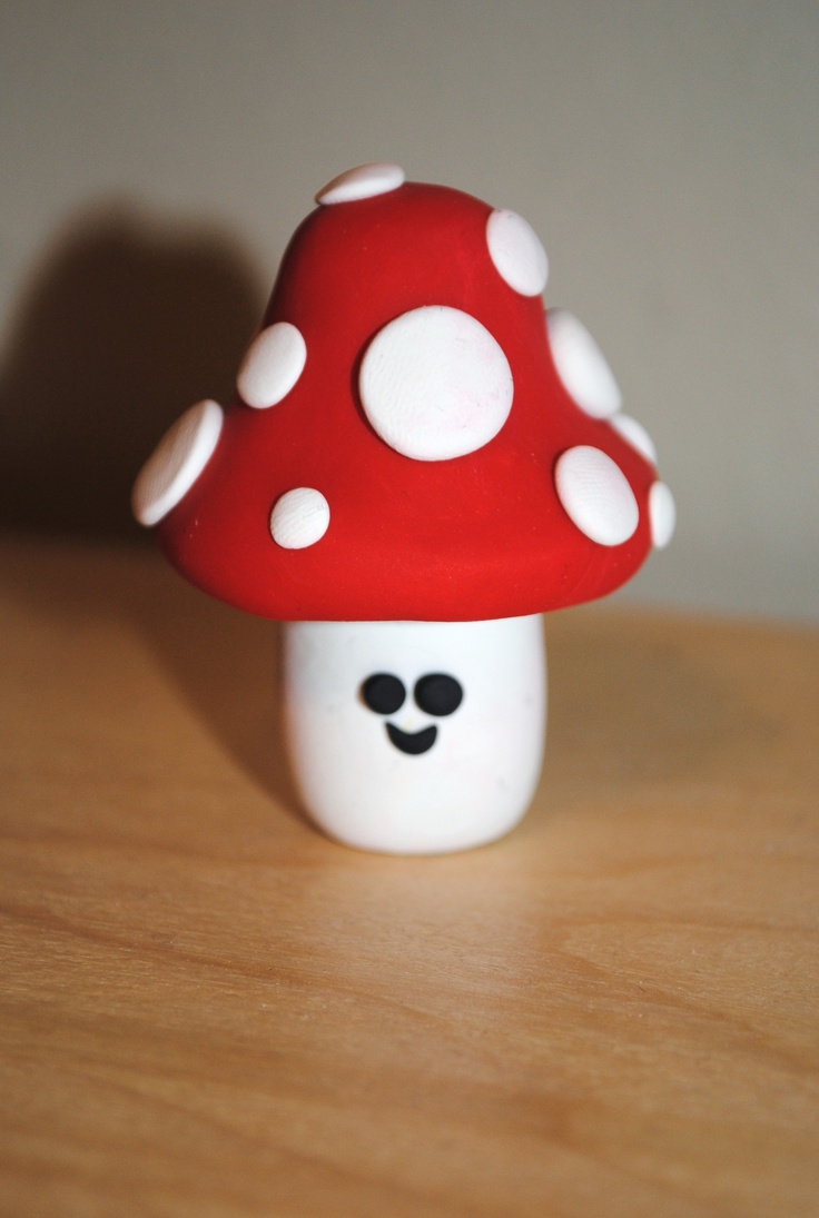 a red and white mushroom sitting on top of a wooden table