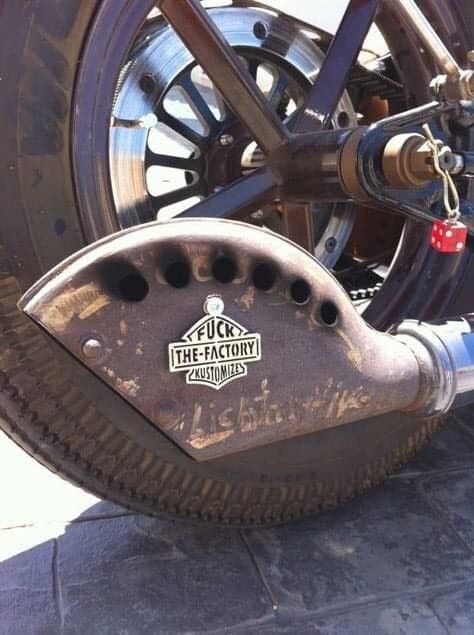 the front wheel of a motorcycle with an emblem on it's tire and chain