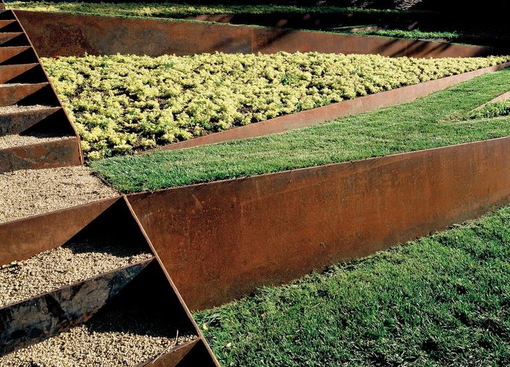 several metal planters with grass growing in them