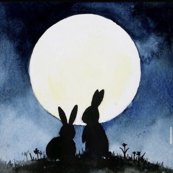 two rabbits sitting in the grass under a full moon