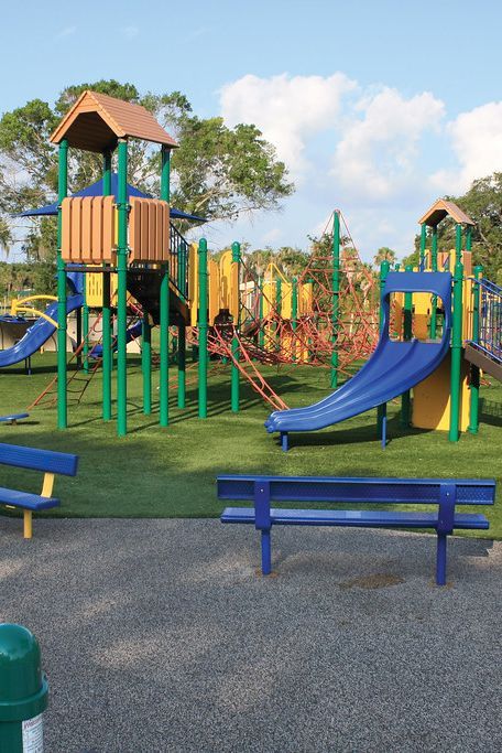 children's play area with blue benches and green slides