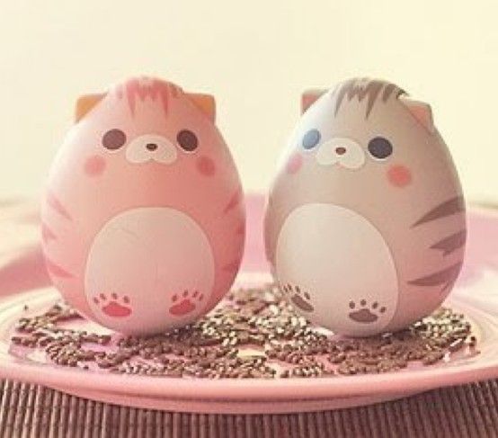 two pink and white eggs sitting on top of a plate with sprinkles