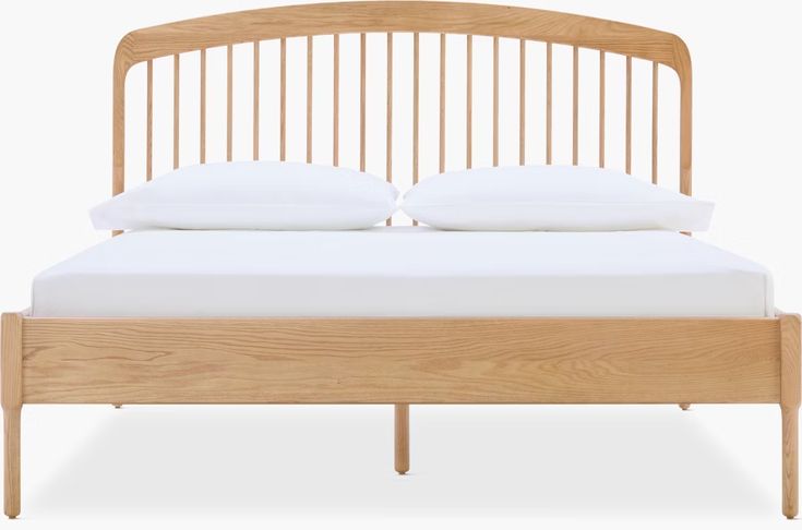 a wooden bed frame with two white pillows