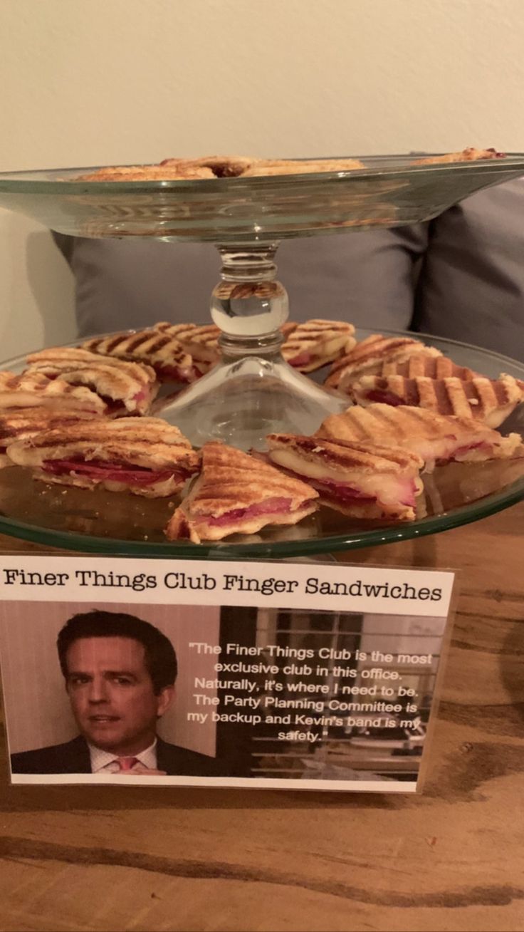 a glass platter filled with pastries on top of a wooden table