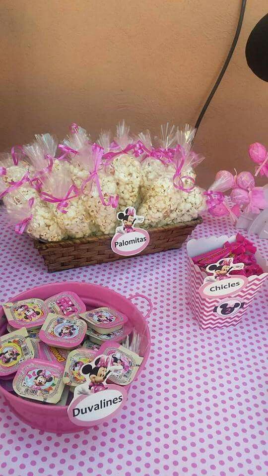 a table topped with lots of pink and white items next to a basket filled with cookies