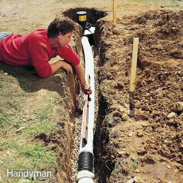 a man laying on the ground next to a pipe