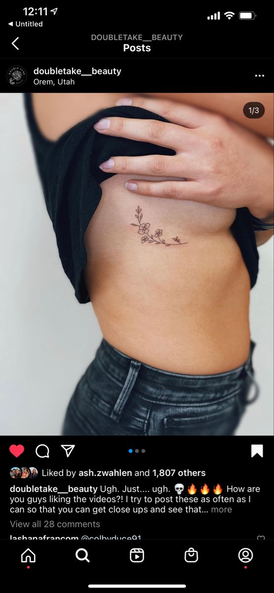 the back of a woman's stomach with flowers on it and an arrow tattoo